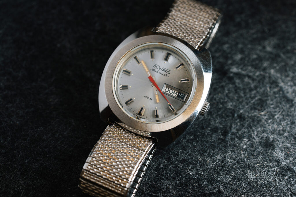 1970s Duward Automatic 100M Internat stainless steel watch with silver dial and Spanish day wheel
