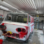 The 1962 Ford Econoline Bulova Racing van is stripped for restoration at Apex Auto Works, revealing minor hidden damage but an exceptionally solid body ready for paint.