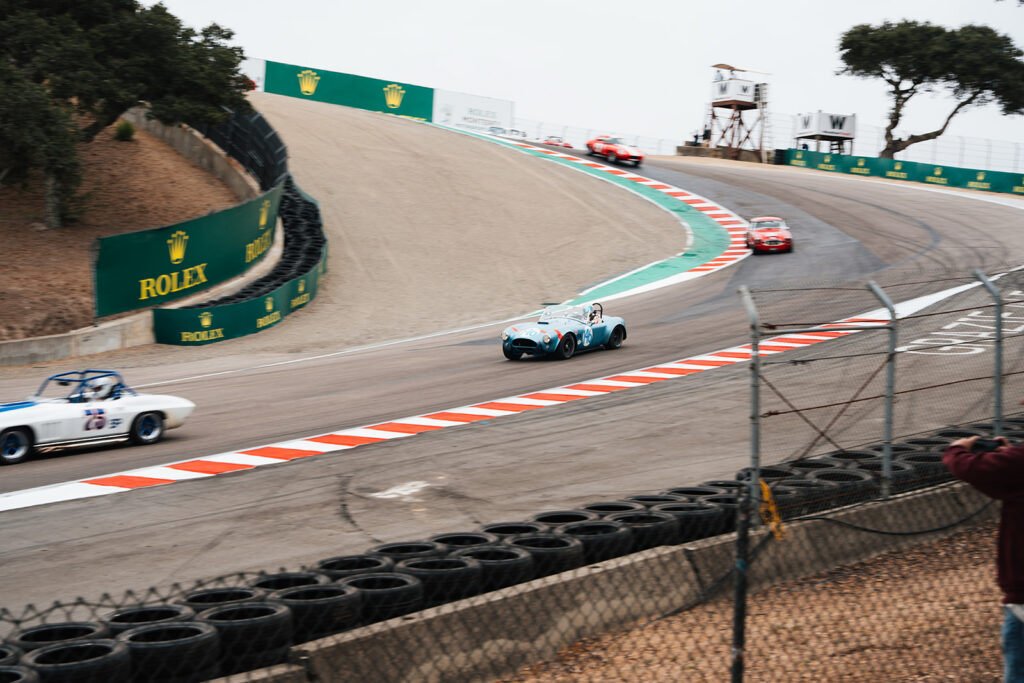 At the 2026 Rolex Monterey Motorsports Reunion, CSX2323 appeared in Group 3 for large-displacement production cars built between 1955 and 1967. The field included other Shelby Cobras, GT350s, Chevrolet Corvettes, Jaguar E-Types, a TVR Griffith, a Sunbeam Tiger, and a Bizzarrini 5300 GT. Driven by Alex MacAllister, number 146 was not treated as a static artifact.